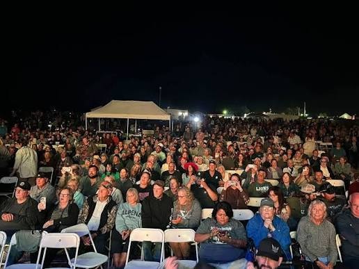 Packed crowd seated under the night sky at Wolf Ridge Amphitheater